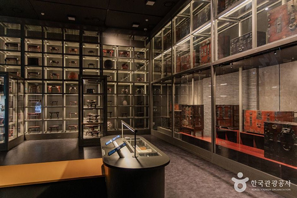 국립민속박물관 파주 어두운 조명 아래 대형 유리 진열장에 전시된 전통 소반과 목가구들