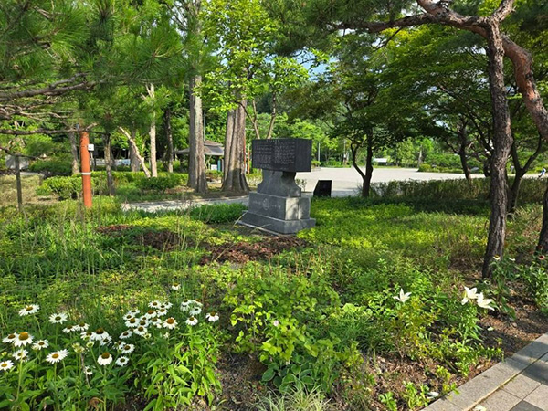 낙성대공원 공원 내 푸른 수풀과 나무들 사이에 세워진 검은색 석비