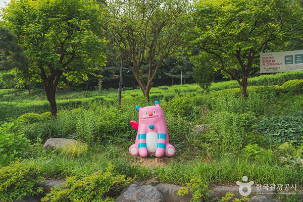 서울 남산야외식물원 풀숲에 앉아 있는 귀여운 캐릭터 조형물