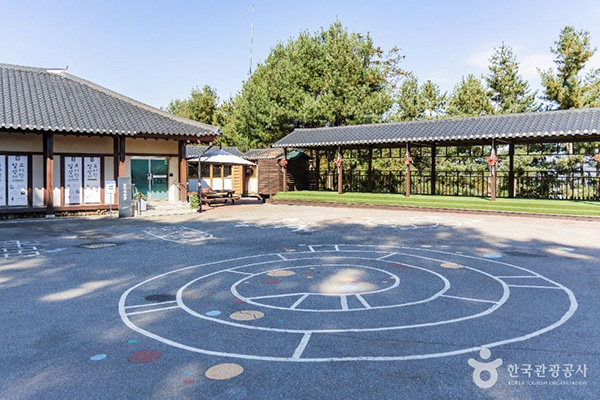 바닥에 전통 놀이 그림이 그려진 용인농촌테마파크의 한옥 체험장 마당